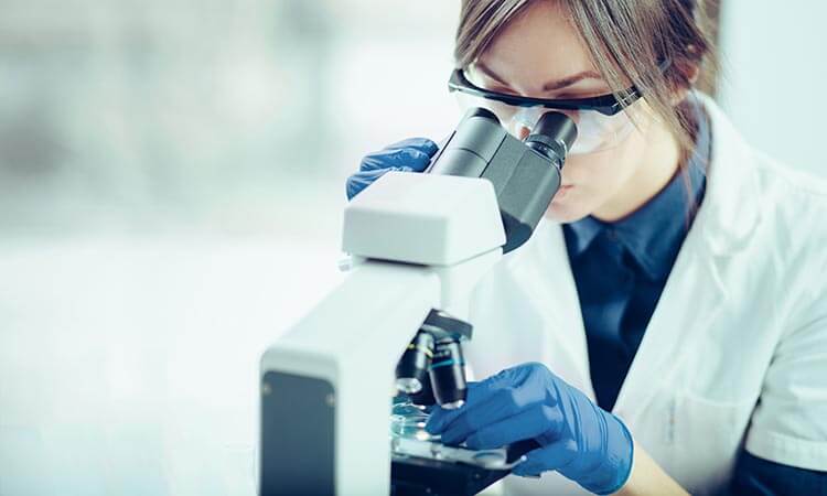 Woman looking into a microscope